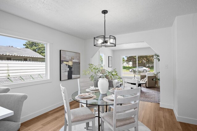 5727 N Cannon St, Spokane, WA 99205 - dining area with a chandelier, light wood-type flooring, baseboards, and a textured ceiling