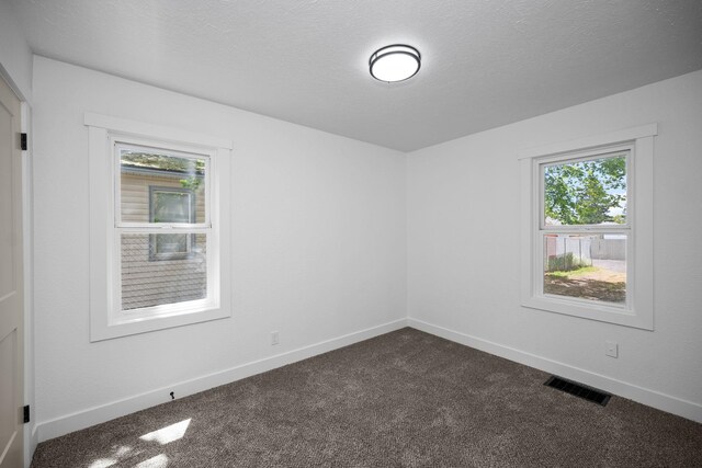 5727 N Cannon St, Spokane, WA 99205 - empty room featuring dark colored carpet, baseboards, and a textured ceiling