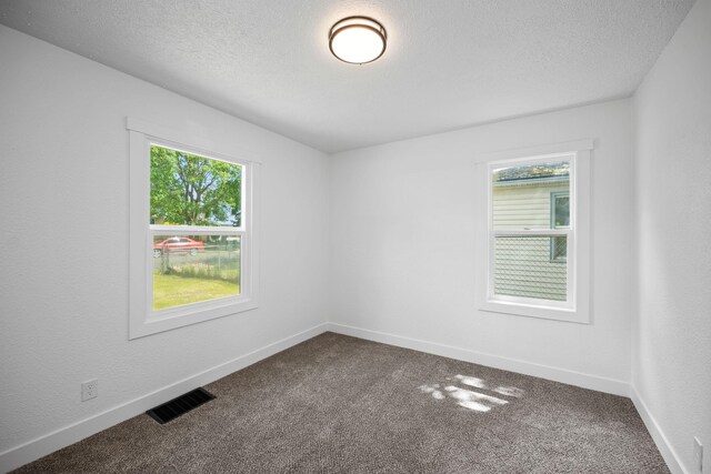 5727 N Cannon St, Spokane, WA 99205 - spare room with dark colored carpet, a textured ceiling, and baseboards