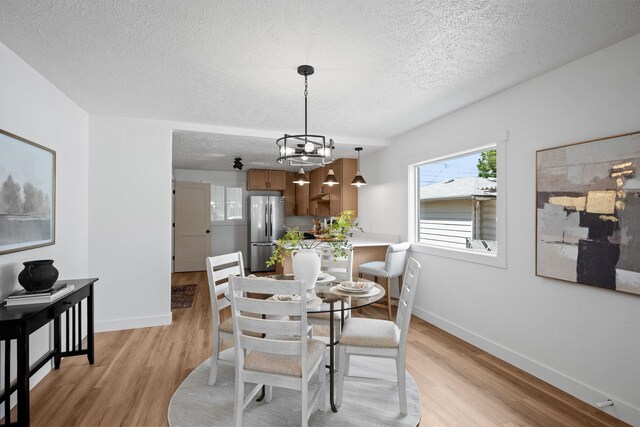 5727 N Cannon St, Spokane, WA 99205 - dining area with a textured ceiling, light wood-style floors, baseboards, and a chandelier