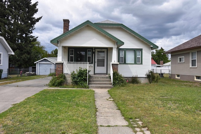 1103 E Longfellow Ave, Spokane, WA 99207 - bungalow-style house with a porch, driveway, a chimney, a garage, and an outdoor structure