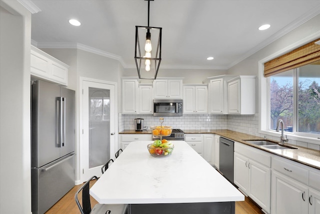 17321 E Morningside Ln, Spokane Valley, WA 99016 - kitchen featuring stainless steel appliances, a sink, white cabinetry, backsplash, and crown molding