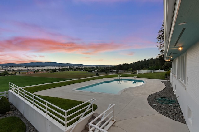 17500 E Wellesley Ave, Spokane Valley, WA 99216 - pool at dusk featuring an outdoor pool, a patio, and a mountain view