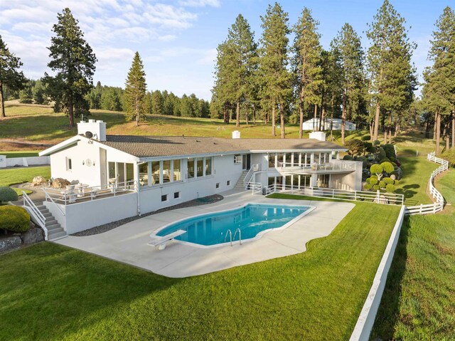 17500 E Wellesley Ave, Spokane Valley, WA 99216 - outdoor pool featuring stairs, a patio area, a diving board, and view of wooded area
