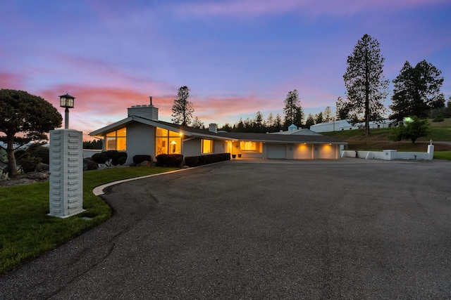 17500 E Wellesley Ave, Spokane Valley, WA 99216 - view of front of home featuring driveway, a chimney, an attached garage, and a front yard