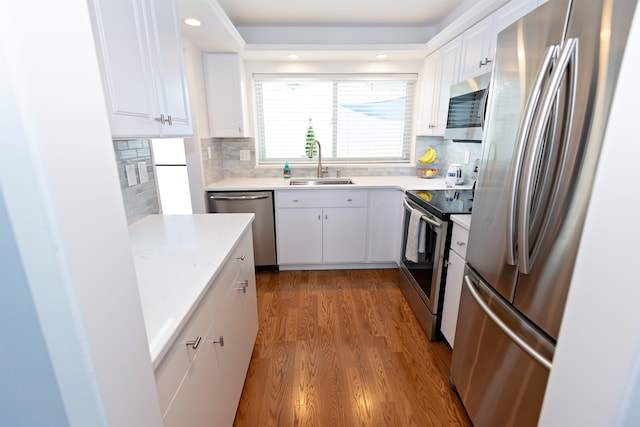 136 E Rockwood Blvd Unit 201, Spokane, WA 99202 - kitchen with stainless steel appliances, a sink, wood finished floors, white cabinetry, and recessed lighting