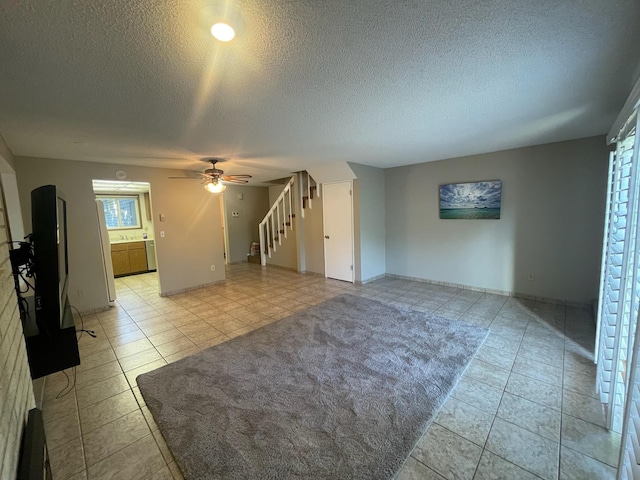 7878 N Wilding Dr Unit 14, Spokane, WA 99208 - unfurnished living room featuring light tile patterned flooring, a textured ceiling, ceiling fan, a sink, and stairs