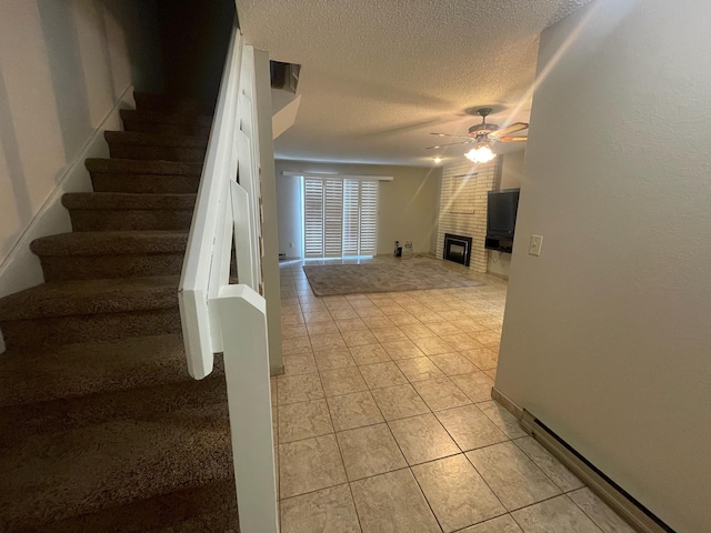 7878 N Wilding Dr Unit 14, Spokane, WA 99208 - stairs with a ceiling fan, tile patterned floors, a textured ceiling, and a fireplace