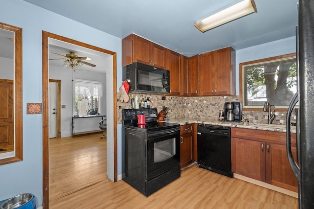 802 10th St, Davenport, WA 99122 - kitchen with black appliances, light wood-style floors, decorative backsplash, a sink, and plenty of natural light