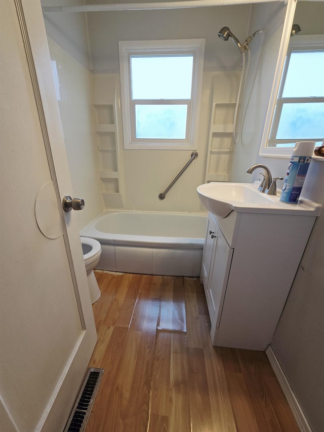 1304 E Hoffman Ave, Spokane, WA 99207 - bathroom featuring vanity, toilet, wood finished floors, and shower / tub combination