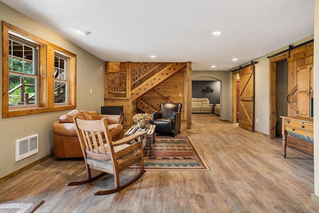 3475B Waitts Lake Rd, Valley, WA 99181 - living room with a barn door, wood finished floors, baseboards, recessed lighting, and wood walls