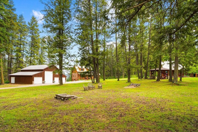 3475B Waitts Lake Rd, Valley, WA 99181 - view of green lawn featuring a detached garage, an outdoor structure, and driveway