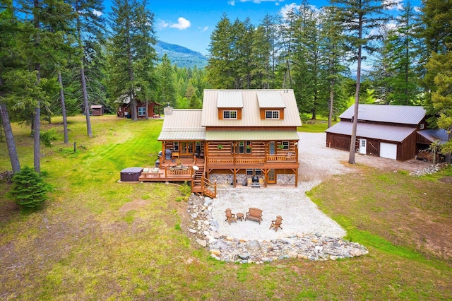 3475B Waitts Lake Rd, Valley, WA 99181 - back of house with a wooden deck, gravel driveway, metal roof, and a lawn