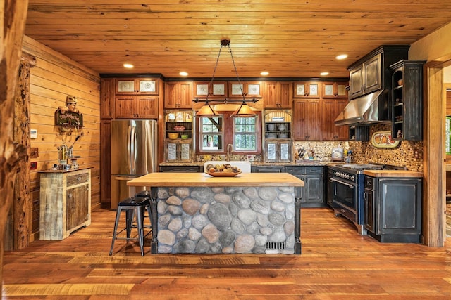 3475B Waitts Lake Rd, Valley, WA 99181 - kitchen with stainless steel appliances, under cabinet range hood, wooden ceiling, glass insert cabinets, and a kitchen island