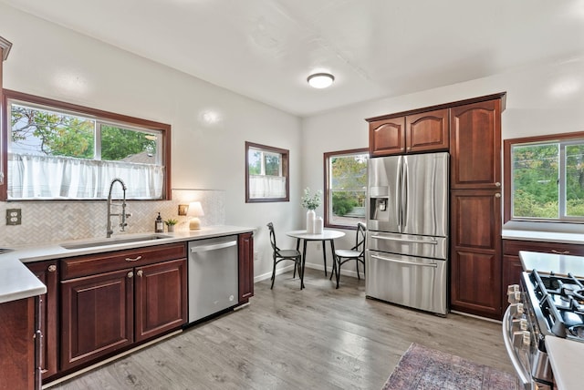1116 E Newark Ave, Spokane, WA 99202 - kitchen with stainless steel appliances, a sink, light wood-type flooring, light countertops, and backsplash