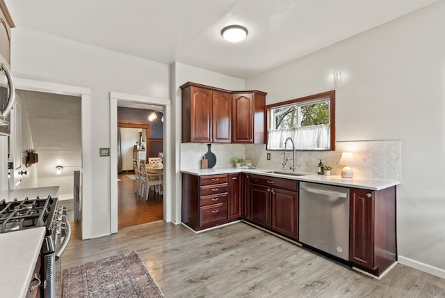 1116 E Newark Ave, Spokane, WA 99202 - kitchen featuring stainless steel appliances, a sink, light countertops, decorative backsplash, and light wood-type flooring