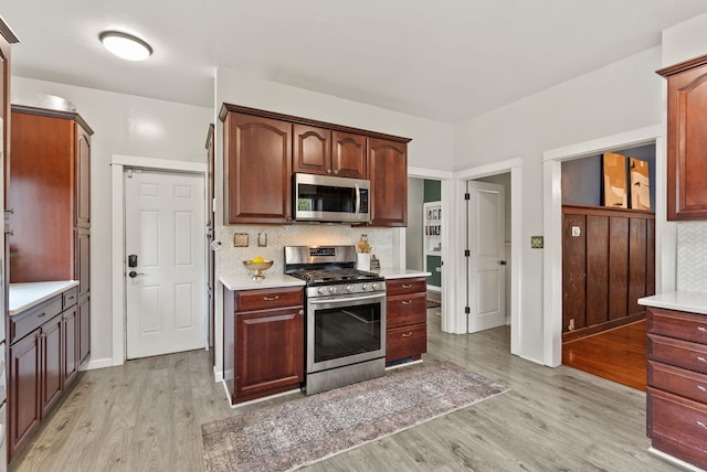 1116 E Newark Ave, Spokane, WA 99202 - kitchen with appliances with stainless steel finishes, light wood-type flooring, light countertops, decorative backsplash, and baseboards