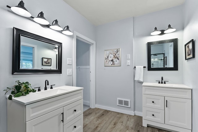 1116 E Newark Ave, Spokane, WA 99202 - full bathroom with wood finished floors, two vanities, and baseboards