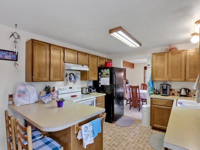 11723 S Player Dr, Spokane, WA 99223 - kitchen featuring electric stove, freestanding refrigerator, under cabinet range hood, light countertops, and a peninsula
