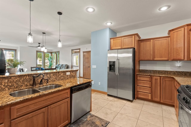 4461 W Greenchain Loop # 5, Coeur D Alene, ID 83814 - kitchen with appliances with stainless steel finishes, a sink, brown cabinets, dark stone countertops, and hanging light fixtures