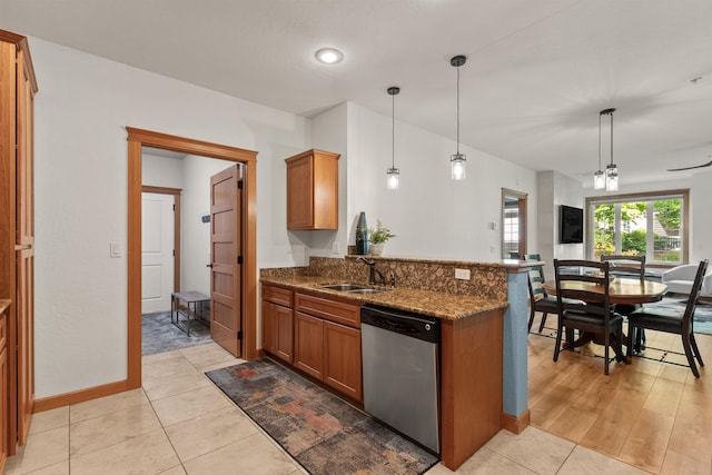 4461 W Greenchain Loop # 5, Coeur D Alene, ID 83814 - kitchen with dishwasher, brown cabinets, dark stone countertops, a sink, and a peninsula