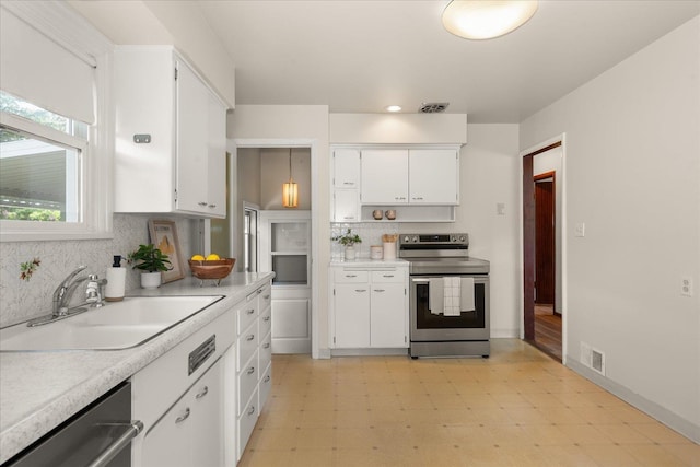 4218 N E St, Spokane, WA 99205 - kitchen with appliances with stainless steel finishes, a sink, light flooring, white cabinetry, and light countertops