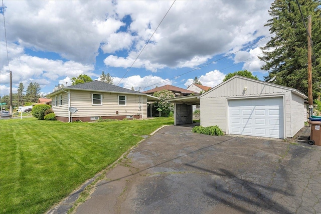 4218 N E St, Spokane, WA 99205 - view of home's exterior featuring a garage, a yard, asphalt driveway, and an outdoor structure