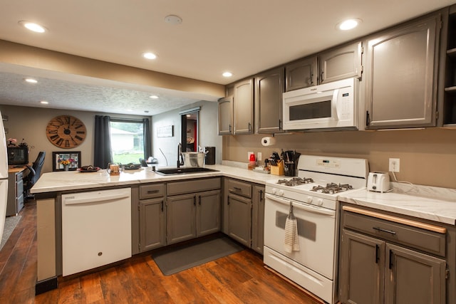 1207 E Bismark Ave, Spokane, WA 99208 - kitchen with white appliances, a peninsula, a sink, dark wood-type flooring, and recessed lighting