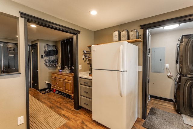 1207 E Bismark Ave, Spokane, WA 99208 - kitchen featuring freestanding refrigerator, electric panel, stacked washing machine and dryer, dark wood-style flooring, and recessed lighting