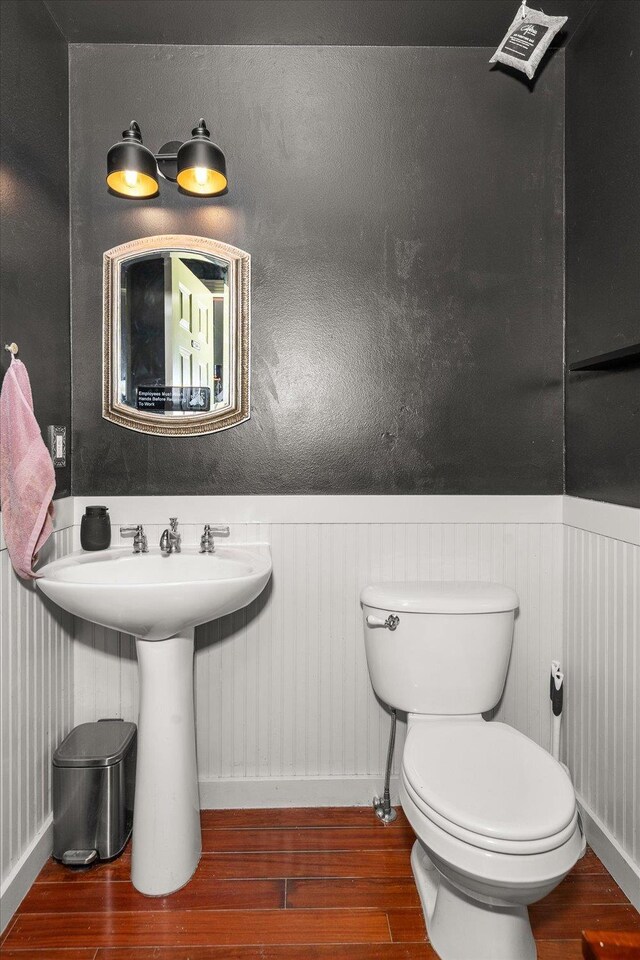 2215 N 8th St, Cheney, WA 99004 - bathroom with wood finished floors, toilet, baseboards, and a wainscoted wall