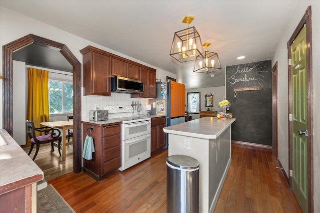 2215 N 8th St, Cheney, WA 99004 - kitchen with double oven range, stainless steel microwave, dark wood-style floors, a chandelier, and a center island