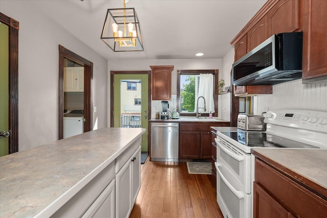 2215 N 8th St, Cheney, WA 99004 - kitchen with stainless steel appliances, a sink, washer / clothes dryer, dark wood finished floors, and hanging light fixtures