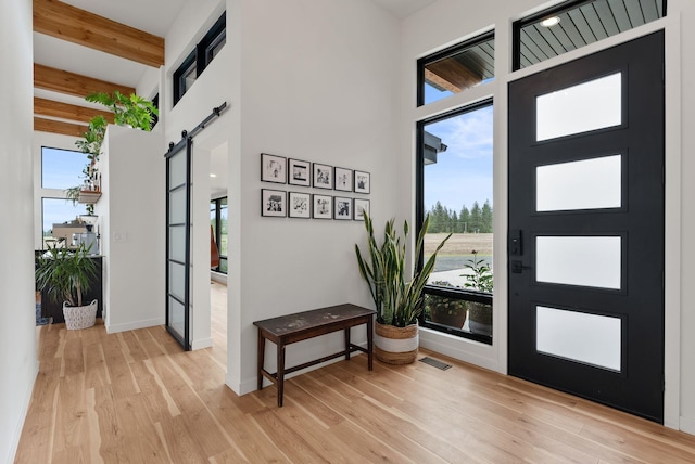 311 N Christensen Rd, Medical Lake, WA 99022 - entrance foyer with a barn door, light wood-style flooring, beamed ceiling, baseboards, and a high ceiling