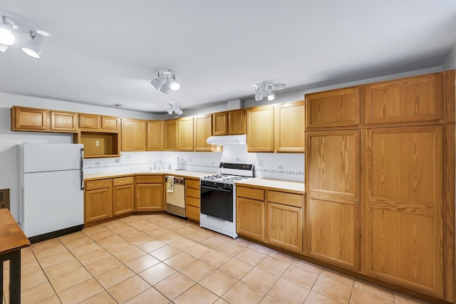 10808 47th Ave, Spokane Valley, WA 99206 - kitchen with white appliances, under cabinet range hood, a sink, light countertops, and tasteful backsplash