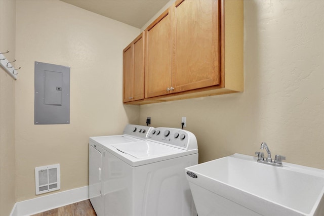 216 6th St, Cheney, WA 99004 - laundry room featuring electric panel, cabinet space, washing machine and dryer, wood finished floors, and baseboards