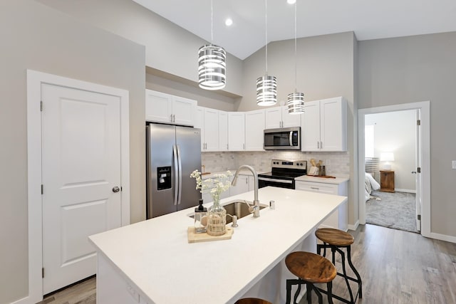 723 S Hatch St, Spokane, WA 99202 - kitchen featuring stainless steel appliances, high vaulted ceiling, a sink, wood finished floors, and a kitchen bar