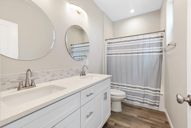 723 S Hatch St, Spokane, WA 99202 - full bath with double vanity, wood finished floors, toilet, decorative backsplash, and a shower with shower curtain