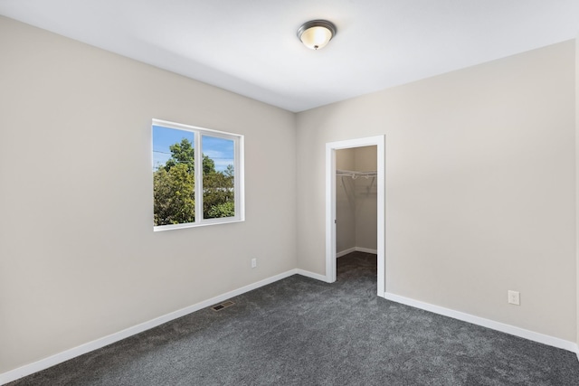 723 S Hatch St, Spokane, WA 99202 - unfurnished bedroom with dark colored carpet, baseboards, a spacious closet, and a closet