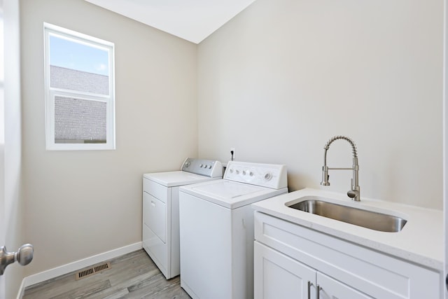 723 S Hatch St, Spokane, WA 99202 - washroom featuring washer and clothes dryer, light wood-style flooring, cabinet space, and baseboards