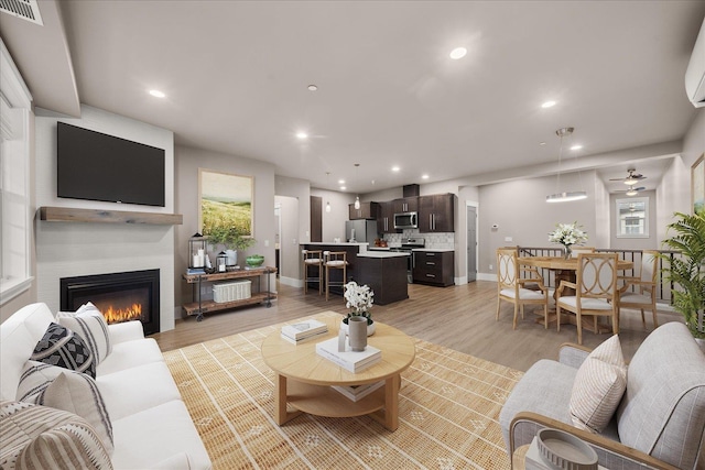 24481 E Pinnacle Ct Unit D, Liberty Lake, WA 99019 - living room with a glass covered fireplace, recessed lighting, baseboards, and light wood-style flooring