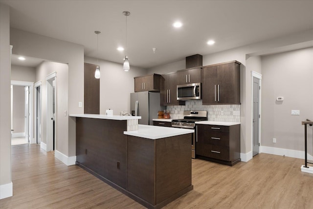 24481 E Pinnacle Ct Unit D, Liberty Lake, WA 99019 - kitchen featuring appliances with stainless steel finishes, dark brown cabinetry, light countertops, tasteful backsplash, and light wood-style flooring