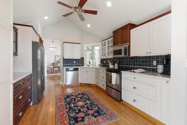8904 E Boardwalk Ln, Spokane, WA 99212 - kitchen with stainless steel appliances, a ceiling fan, glass insert cabinets, decorative backsplash, and light wood-style floors