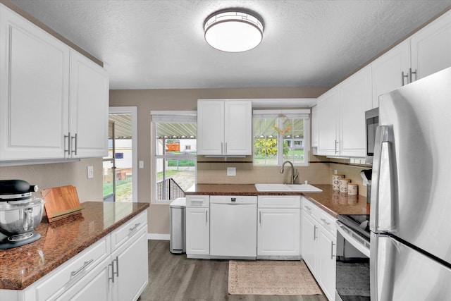1419 E Glass Ave, Spokane, WA 99207 - kitchen with dishwasher, freestanding refrigerator, stainless steel electric range oven, a sink, and light wood finished floors