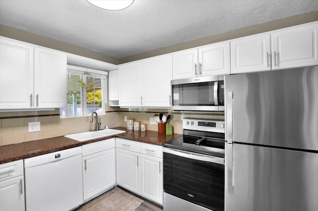 1419 E Glass Ave, Spokane, WA 99207 - kitchen with stainless steel appliances, a sink, tasteful backsplash, dark countertops, and a textured ceiling