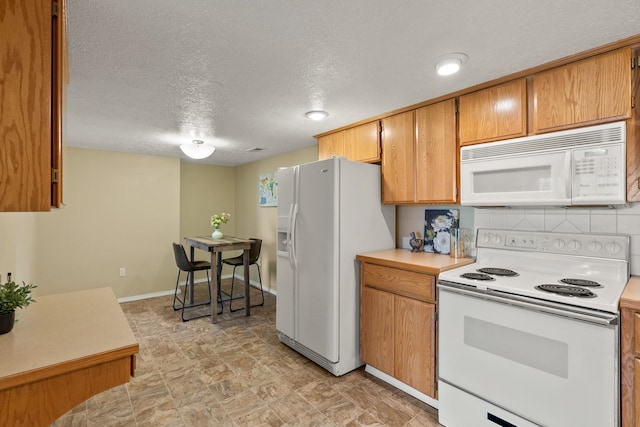 14716 E 48th Ln, Veradale, WA 99037 - kitchen featuring white appliances, light countertops, a textured ceiling, baseboards, and brown cabinetry