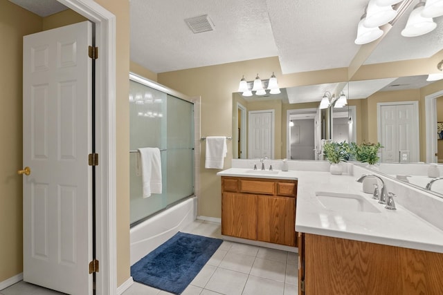 14716 E 48th Ln, Veradale, WA 99037 - full bathroom featuring double vanity, combined bath / shower with glass door, tile patterned flooring, baseboards, and a textured ceiling