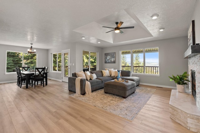 14716 E 48th Ln, Veradale, WA 99037 - living room featuring light wood-style floors, baseboards, a stone fireplace, and a textured ceiling