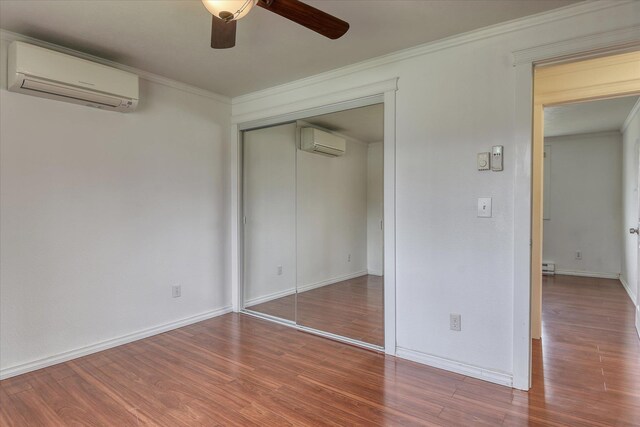 11920 E Railroad Ave, Spokane, WA 99206 - unfurnished bedroom with an AC wall unit, wood finished floors, a closet, and crown molding