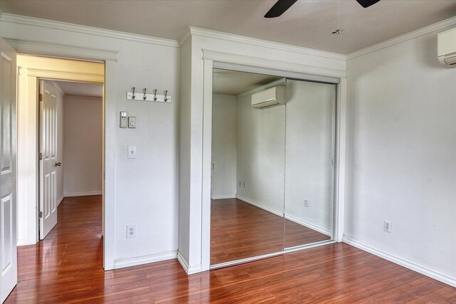 11920 E Railroad Ave, Spokane, WA 99206 - unfurnished bedroom with a wall unit AC, wood finished floors, a closet, baseboards, and ornamental molding