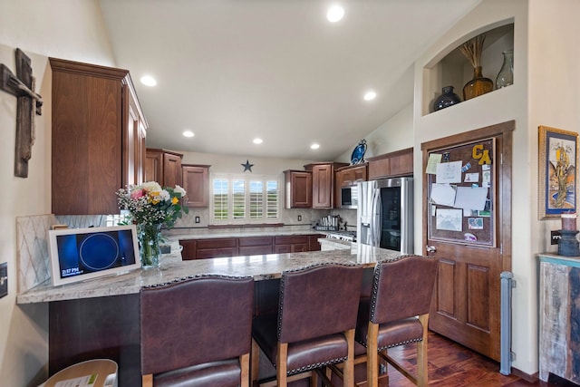 14410 W Jacobs Rd, Spokane, WA 99224 - kitchen with appliances with stainless steel finishes, a peninsula, backsplash, light stone countertops, and dark wood finished floors